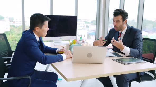 Two Business People Talk Project Strategy at Office