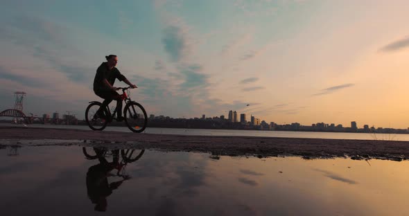 Silhouette of Bicyclist Riding Bike at Sunset Slow Motion