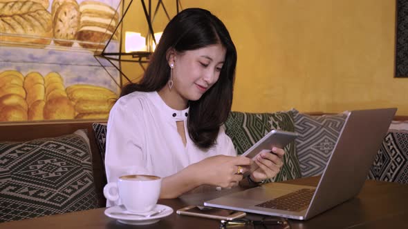 Beautiful Asian Girl Working With Tablet In Coffee Shop