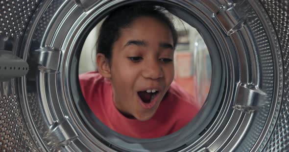 View From Inside the Drum a Girl Has a New Washing Machine at Home She Looks at It with Curiosity