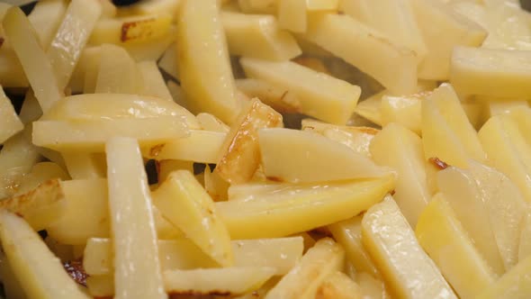 Cooking Fried Potato on Frying Pan. Roasting Sliced Potatoes