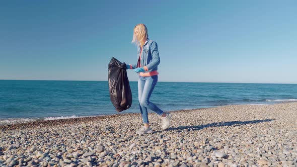 a woman collecting cleaning plastic bottles on the beach,