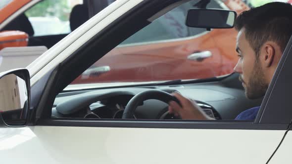 Cheerful Young Handsome Man Smiling To the Camera Sitting in His New Car