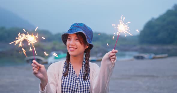 Woman play with sparkler in the evening