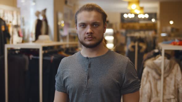 Young Handsome Confident Man Looking at Camera Standing at Clothing Store
