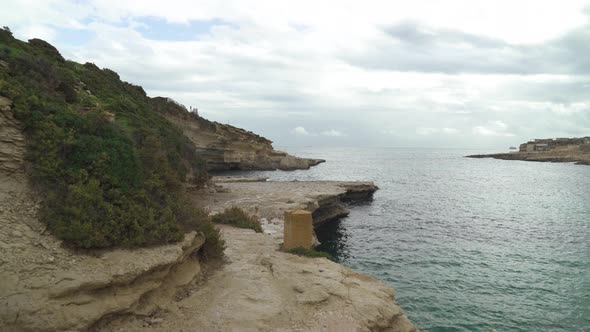 Walking on Il-Kalanka Beach in Malta with Splashing Turquoise Colour Water in Bay