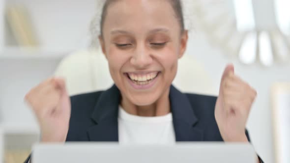 Close Up of African Businesswoman Celebrating Success on Laptop 