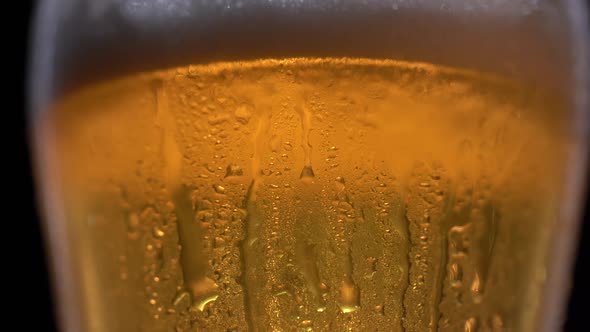 Cold Light Beer in a Glass with Water Drops Over Matte Black Background Border Design