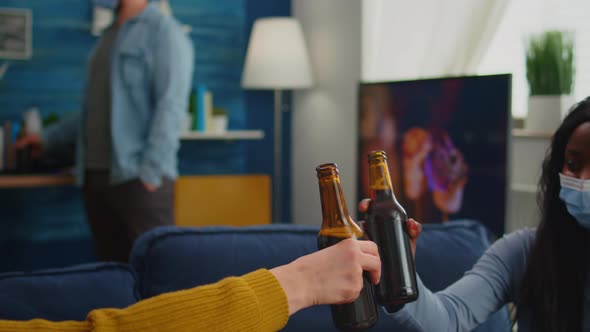 Close Up of Young People Hands Toasting and Cheering Bottle of Beers