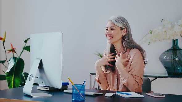 Happy Mature Asian Woman Communicate By Video Call on Computer Working From Home