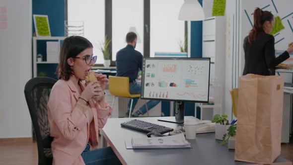 Businesswoman Eating Tasty Sandwich Having Meal Break Working in Business Company