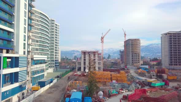 Drone view of construction of multi-storey buildings background of mountains.