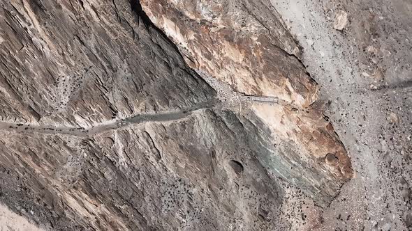 Car Driving On Winding Road Of Karakoram Near Khunjerab Pass In Pakistan. - aerial.  Dangerous road