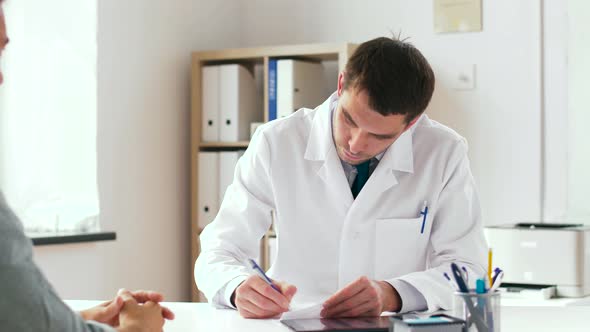 Doctor Writing Prescription for Patient at Clinic 11