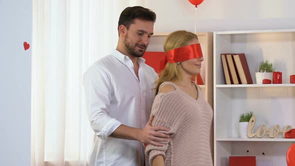 Man Leads Woman With Tied Eyes to Room With Romantic Decoration, Valentines Day