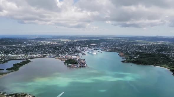 Coastal city with liner in harbor and boat is sailing on sea in Saint John's, Antigua and Barbuda