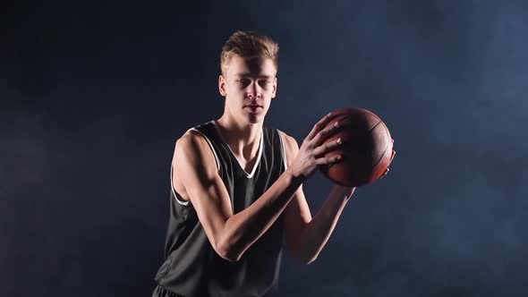 A Young Basketball Player is Practicing a Serve with the Ball