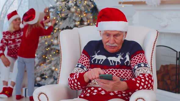 Senior Old Grandfather Man Buy Christmas Gift Presents Doing Online Shopping on Mobile Phone at Home