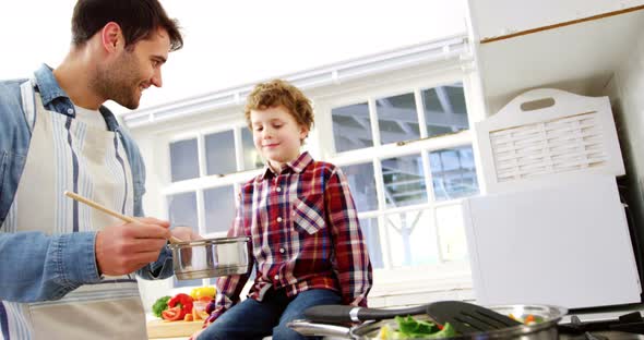 Boy looking while father cooking food