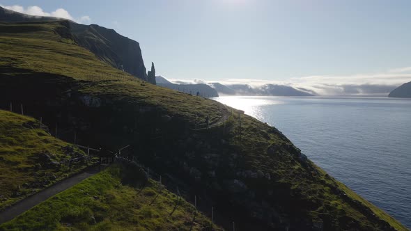 Drone Over Man Walking Footpath Along Coastline