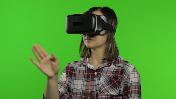 Girl Using VR App Helmet To Play Simulation Game. Slide Gestures. Watching Virtual Reality 3d Video
