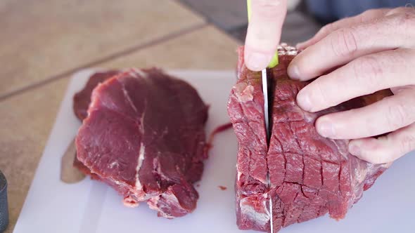 Tight shot of man cutting roast into slices