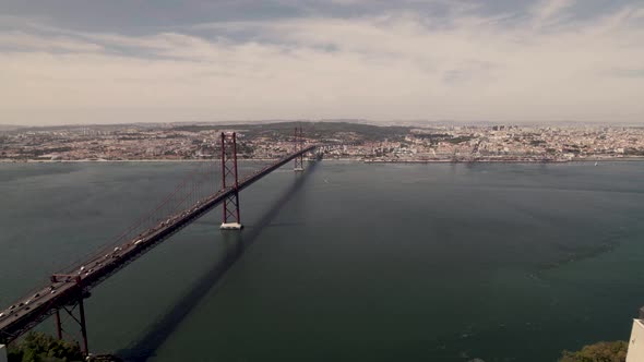 Aerial overlooking at Lisbon capital city, reveals clifftop statue of Cristo Rei in Almada.