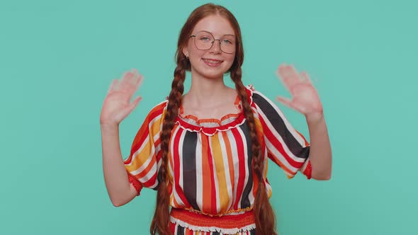 Redheaded Girl Smiling Friendly at Camera and Waving Hands Gesturing Hello or Goodbye Welcoming