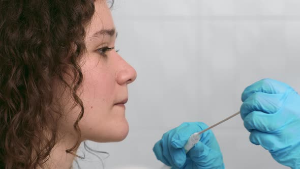 Laboratory Worker Taking PCR Throat Sample for Covid19 Test From Young Female Patient