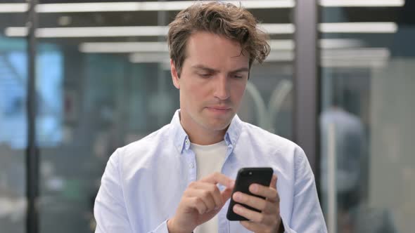 Portrait of Man Having Loss While Using Smartphone