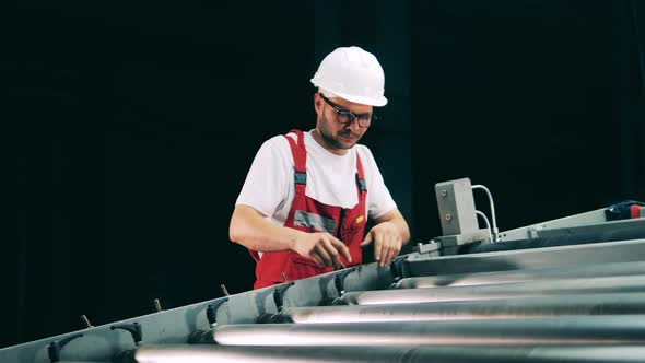 Factory Worker Is Fixing a Rolling Conveyor