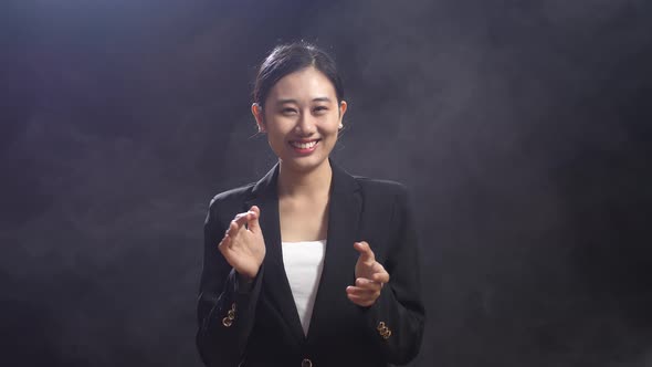 Smiling Asian Speaker Woman In Business Suit Clapping Her Hands And Looking Around On Stage
