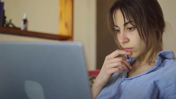 Concerned Woman Working on Laptop Computer at Home