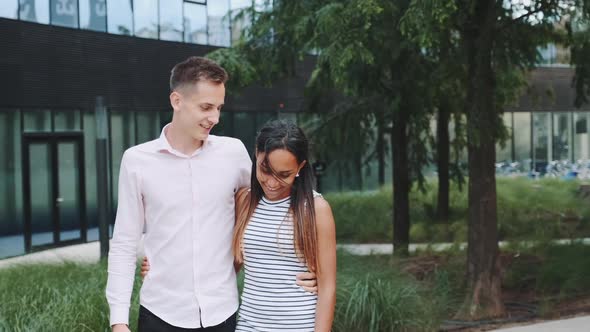 Multiethnic Couple in Love Shyly Looking at Each Other Talking and Walking Down the Street