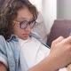 Little Cute Boy with Eyeglasses Sitting on Sofa and Playing Game on Digital Tablet Closeup Portrait - VideoHive Item for Sale