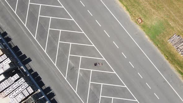 One man lying on parking area on road