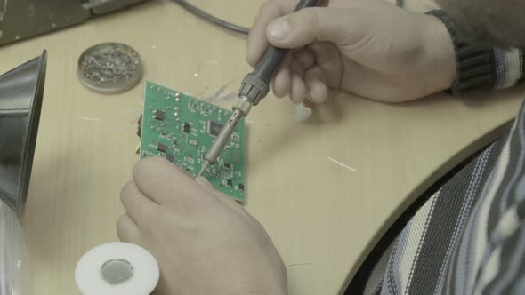 A Worker Is Working on the Production of an Electronic Board. Close-up.