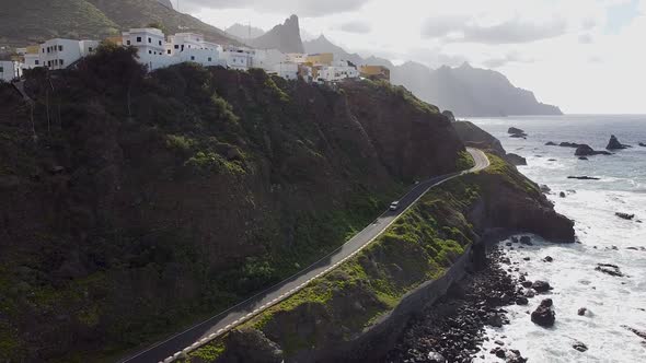 Aerial drone view of a coastal road and a village above it in Benjio, Anaga National Park, Northern