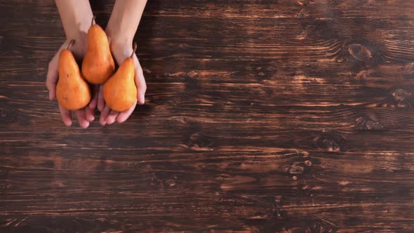 Unrecognizable Woman Holding Fruits Over the Wooden Table