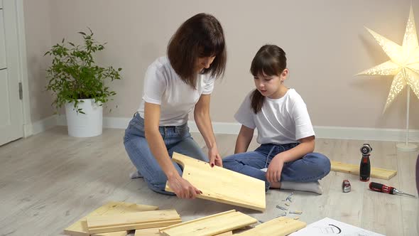 Happy Family Mother and Daughter Assembling Wooden Furniture Together