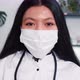Closeup Young Happy Mixed Race Female Doctor Wearing Face Mask Lab Coat Smiles at Camera at Light - VideoHive Item for Sale