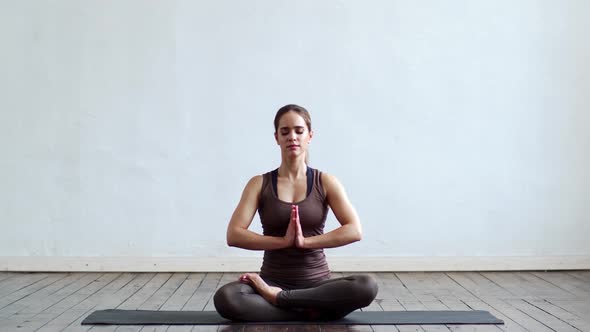 Young and fit woman practicing yoga indoor in the class.