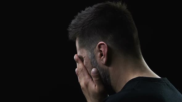 Poor Miserable Male Deeply Crying Isolated on Dark Background