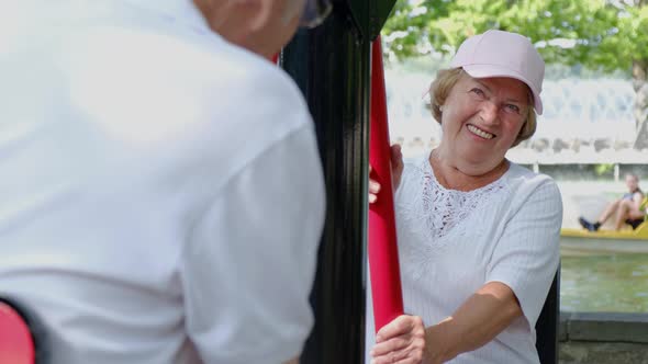 Happy retired couple playing sports outdoors on a beautiful sunny summer day.