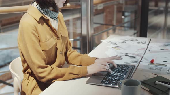 Female Fashion Designer Working on Laptop at Desk