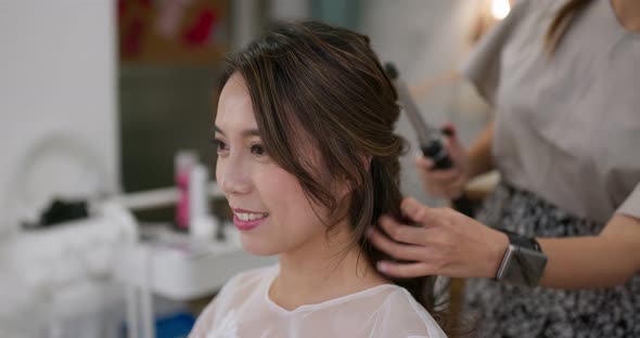 Stylist makes hair for bride