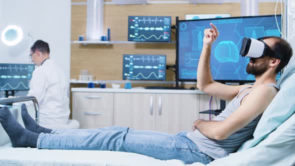 Patient Sitting on Hospital Bed Wearing Virtual Reality Goggles