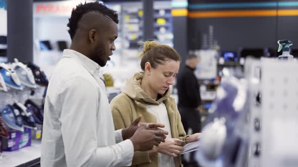 Shop Assistant Giving Advice to Woman in Store