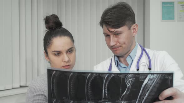 Doctor and Patient Looking at MRI Scan on Medical Appointment