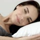Young woman lying in bed turning to look at camera - VideoHive Item for Sale